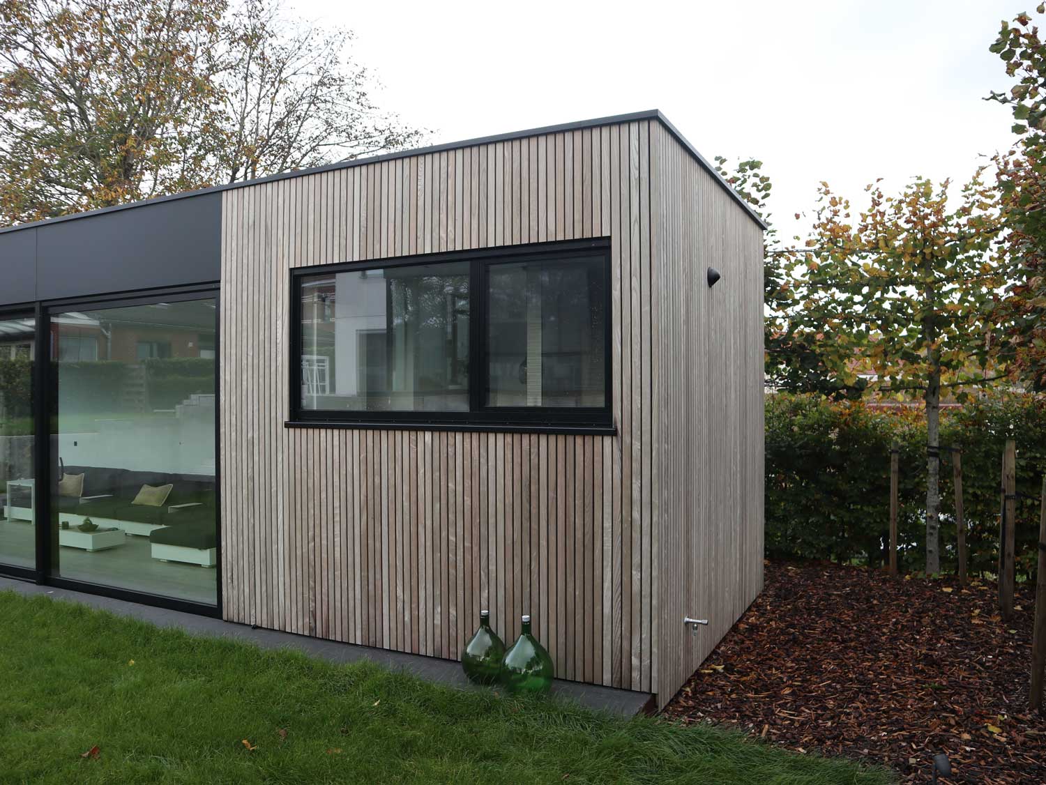 Een bijgebouw in hout staal constructie, volledig door ons gebouwd (van A tot Z) van de funderingen tot het tegelen, plaatsen van de inbouwkasten, douche, toilet, lavabo’s… de gevels zijn bekleed met alucobond en hotwood essen. | Woodz Design | Zander Steels